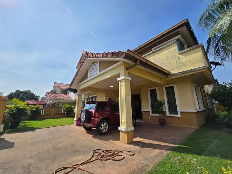 Exterior type: detached bungalow; features: cream painted facade, pitched tile roof, single-storey, manicured lawn, paved driveway, car porch with awning, tropical landscaping, mature trees, decorative columns, windows with green shutters; style: tropical-modern.