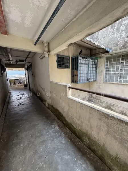 Room features: concrete flooring, white painted walls, metal railing, windows with metal grilles, exposed ceiling, natural light from windows, corridor layout.