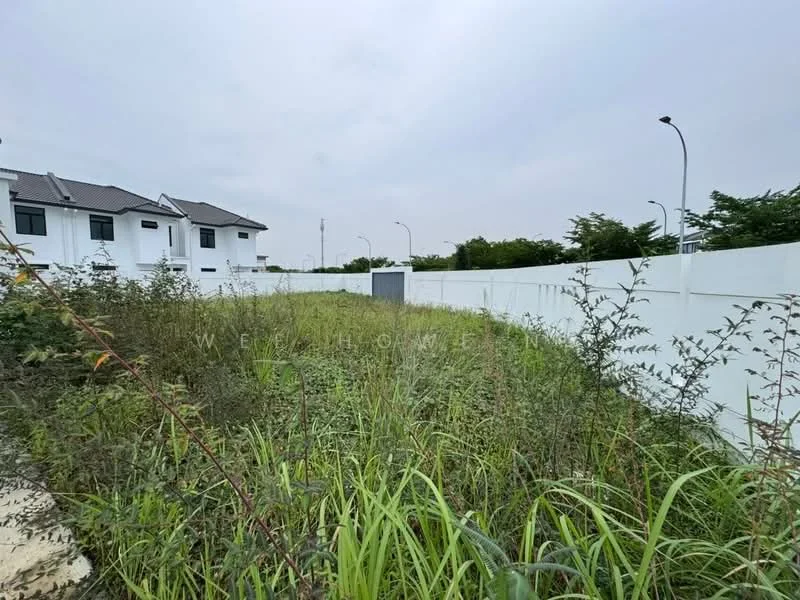 Exterior features: overgrown grass, fenced perimeter, white boundary wall, paved pathway, adjacent residential buildings, street lighting, open space.