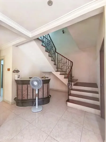 Room features: staircase with wrought iron railing, tiled flooring, cream painted walls, ceiling with crown moulding, recessed lighting, wooden steps, fan, reception counter, wall-mounted light fixture; style: modern.