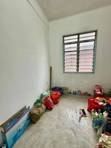 Room features: white painted walls, concrete flooring, large window with multiple panes, various bags and items on the floor.