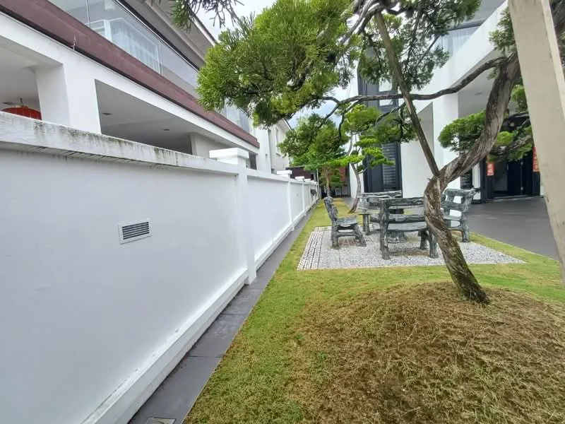 Exterior type: linked terrace house; features: white painted facade, manicured lawn, gravel pathway, outdoor dining set with chairs, decorative tree, surrounding greenery, concrete wall, paved walkway; style: modern.