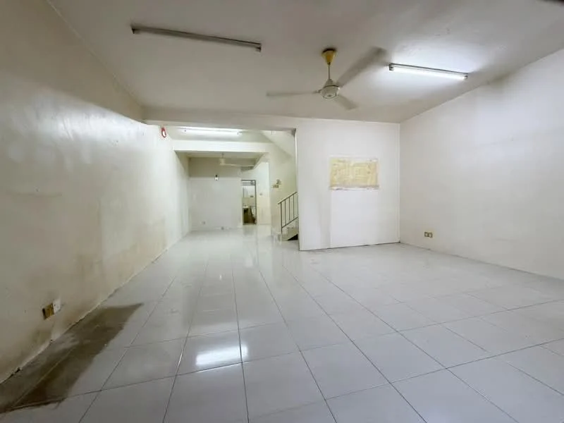 Room features: white painted walls, glossy white tile flooring, ceiling fan, fluorescent ceiling lights, staircase visible in background, empty space, no visible furniture, no visible decor; style: minimalist.