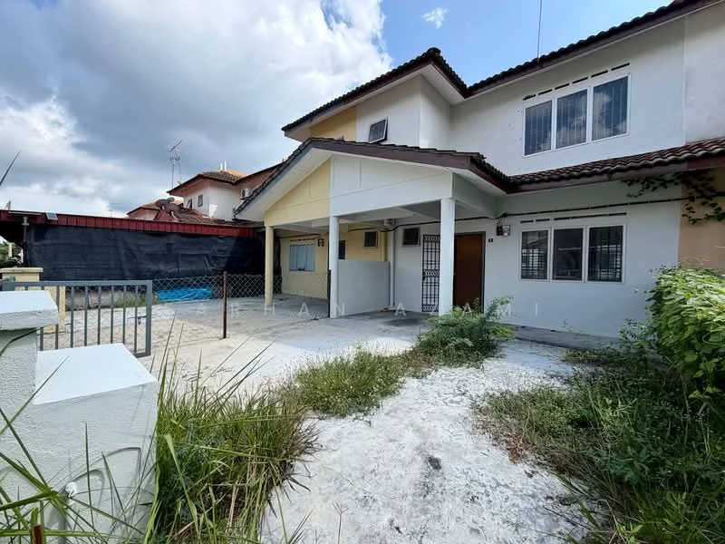 Exterior type: semi-detached house; features: two-storey structure, white painted facade, brown tiled roof, front porch area, fenced yard, overgrown grass, concrete pathway, windows with white frames, visible utility poles, adjacent properties in background; style: modern.