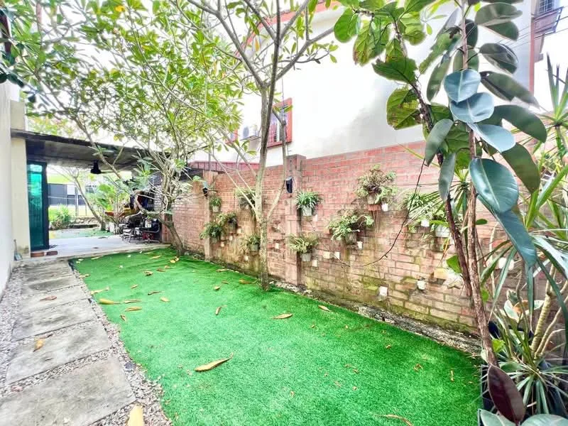 Exterior features: artificial grass lawn, brick wall with greenery, vertical garden with plants, paved walkway, mature trees, outdoor space with landscaping; style: modern.