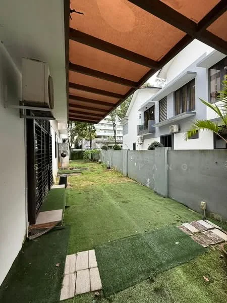 Exterior type: linked terrace house; features: green grass lawn, paved walkway, overhanging roof with wooden beams, wall-mounted split AC unit, fenced garden area, adjacent residential buildings; style: modern.