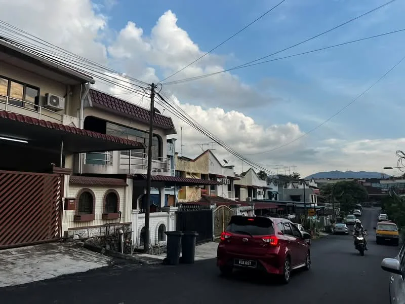 Exterior type: linked terrace house; features: two-storey linked terrace houses, red tiled roof, white painted facade, balconies on upper floors, manicured front gardens, driveways with interlocking pavers, street view with parked cars, overhead power lines, sidewalk along the street, urban residential setting; style: modern.