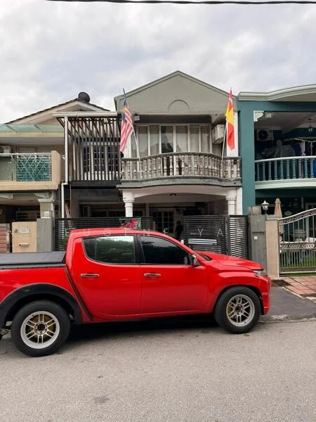 Exterior type: linked terrace house; features: two-storey building, white painted facade, balcony with railing, front porch, visible flags on facade, driveway with parked red pickup truck, manicured lawn, stone-paved walkway, gated entrance, decorative columns, overhanging eaves; style: modern.