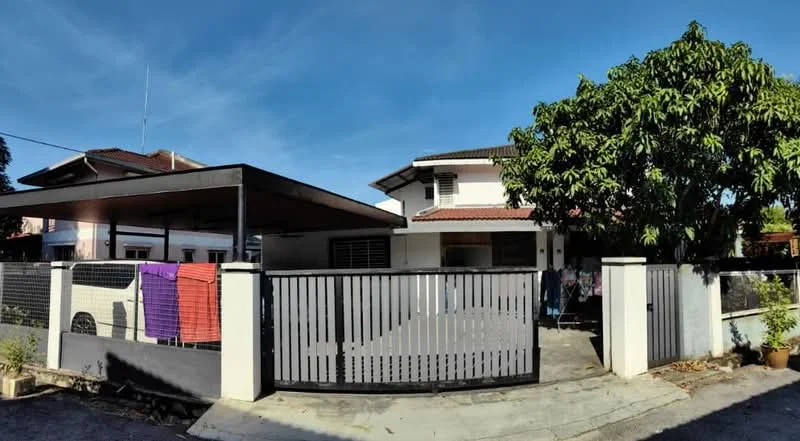 Exterior type: detached bungalow; features: white painted facade, flat roof, single-storey, manicured lawn, car porch with awning, perimeter fence, laundry hanging on the fence, mature trees, driveway with interlocking pavers; style: modern.