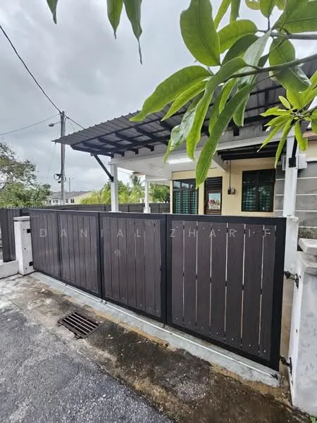 Exterior type: detached bungalow; features: wooden gate, concrete fence, covered porch, paved driveway, landscaped garden, overhead roof, outdoor lighting, surrounding greenery; style: modern.