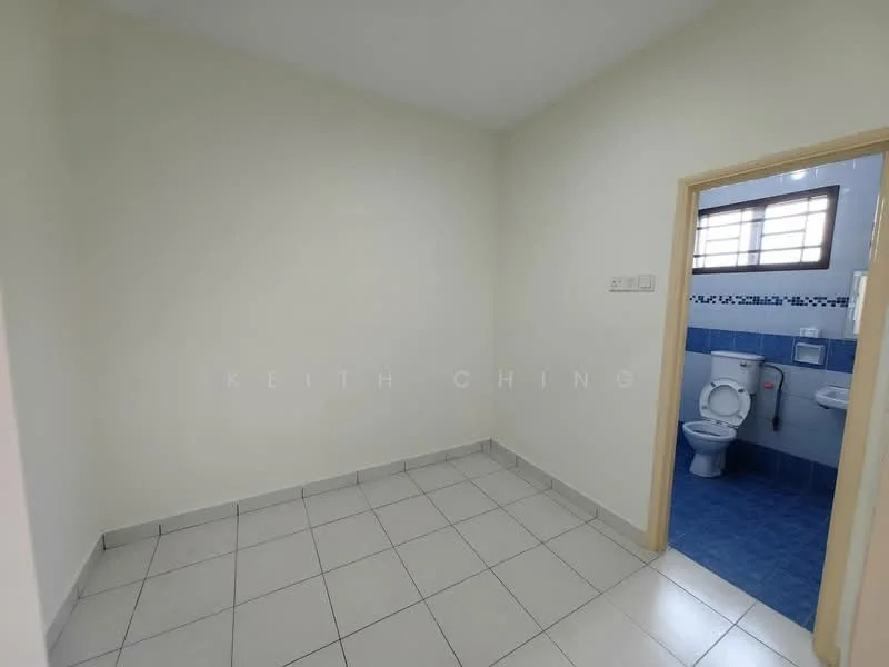 Room features: white painted walls, grey tiled flooring, window with horizontal slats, doorway leading to bathroom, blue tiled wall in bathroom, white toilet, blue floor tiles in bathroom, light fixture on ceiling.