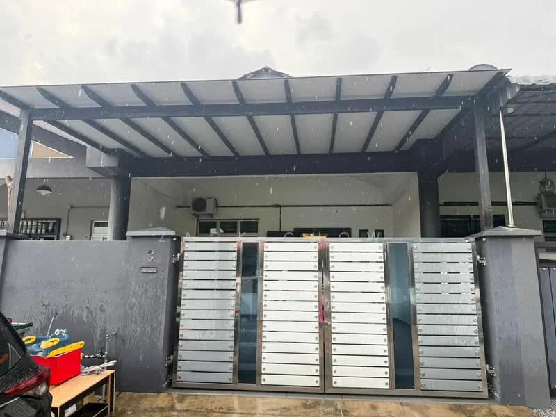 Exterior type: linked terrace house; features: metal gate with multiple mailboxes, covered porch area with roof, grey painted facade, concrete flooring, overhead beams, outdoor lighting fixtures, surrounding walls, rainwater visible on surface; style: modern.