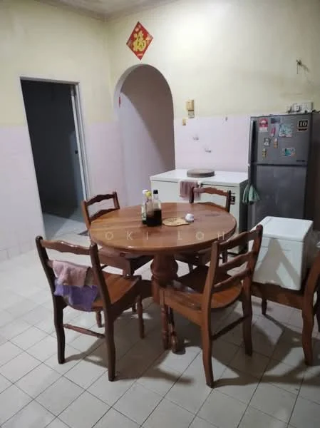 Kitchen features: round wooden dining table, 4 wooden chairs, white cabinetry, stainless-steel fridge, white countertop, pink tiled walls, cream painted walls, tile flooring, doorway leading to another room.