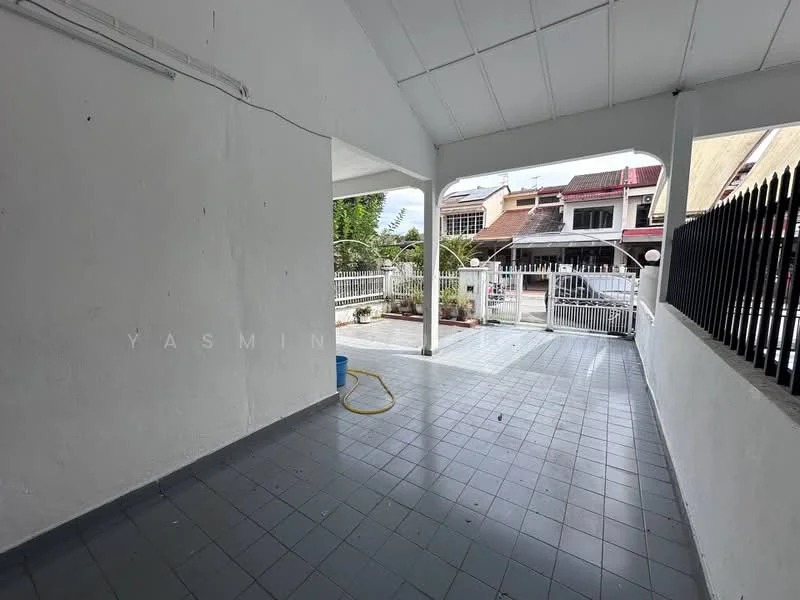 Room features: white painted walls, grey tiled flooring, high ceiling, open space, doorway leading outside, visible outdoor area, hose pipe, fenced area.