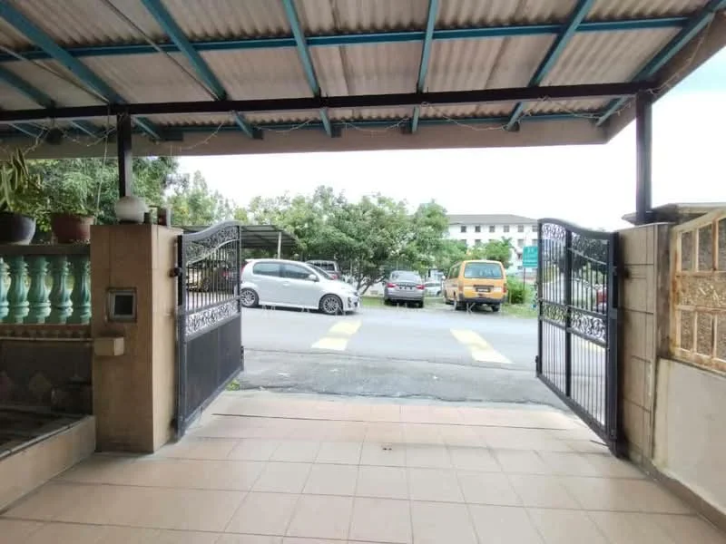 Exterior type: linked terrace house; features: gated entrance, paved driveway, open-air car porch, metal gate, roofed overhang, landscaped garden area, surrounded by greenery, visible parking spaces; style: modern.