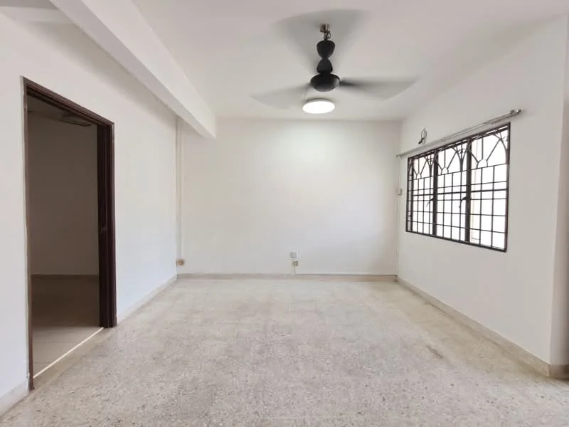 Living features: white painted walls, ceiling fan with 3 blades, large window with metal grille, neutral flooring, light fixture, no visible furniture, open layout, natural light; style: minimalist.