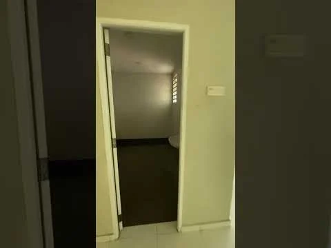 Room features: white painted walls, grey tiled flooring, window with horizontal slats, doorway leading to another room, light ceiling, neutral color scheme.