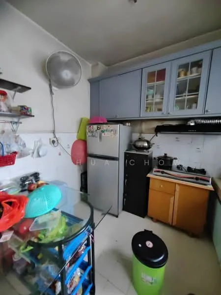 Kitchen features: grey cabinetry, white walls, ceramic tile flooring, stainless-steel fridge, black freestanding stove, kitchen sink, glass dining table, plastic storage containers, exhaust hood, wall-mounted fan, open shelving, green trash bin.
