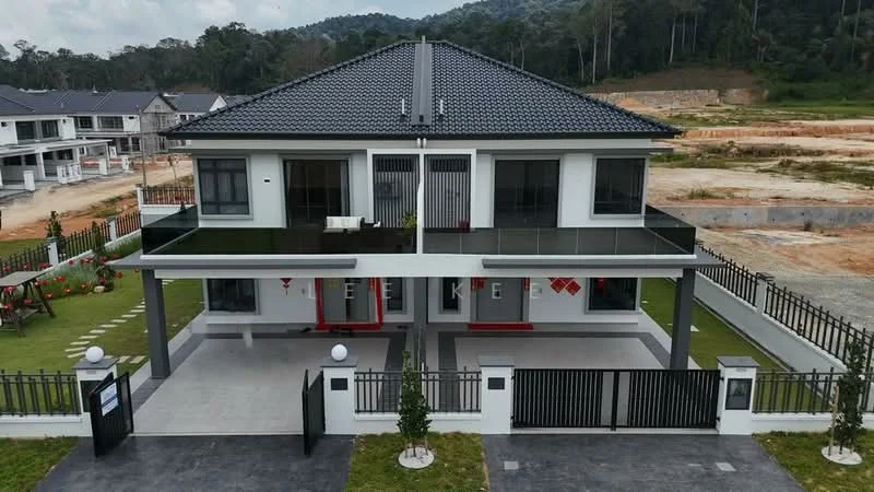 Exterior type: semi-detached house; features: two-storey structure, grey tiled roof, white painted facade, black glass balcony railings, manicured lawn, paved driveway, decorative fence, outdoor lighting, landscaped garden, front porch with seating, surrounded by greenery, mountain view in background; style: modern.