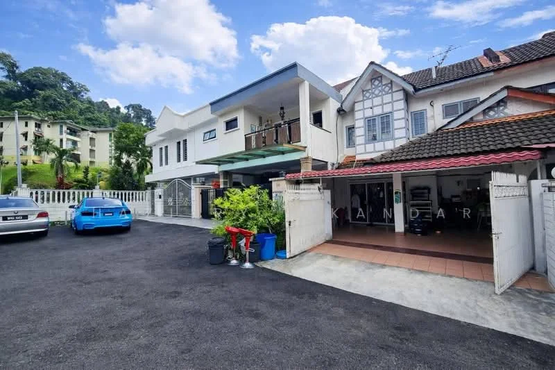 Exterior type: semi-detached house; features: two-storey building, white painted facade, red tiled roof, balcony on upper floor, car porch with space for two cars, manicured garden area, paved driveway, surrounded by greenery, adjacent to residential buildings, visible parking area; style: modern.