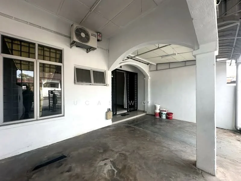 Exterior type: linked terrace house; features: white painted facade, arched entryway, concrete flooring, 1 wall-mounted split AC, windows with grid pattern, covered porch area, black security gate, painted walls, exposed ceiling, outdoor space with minimal landscaping; style: modern.