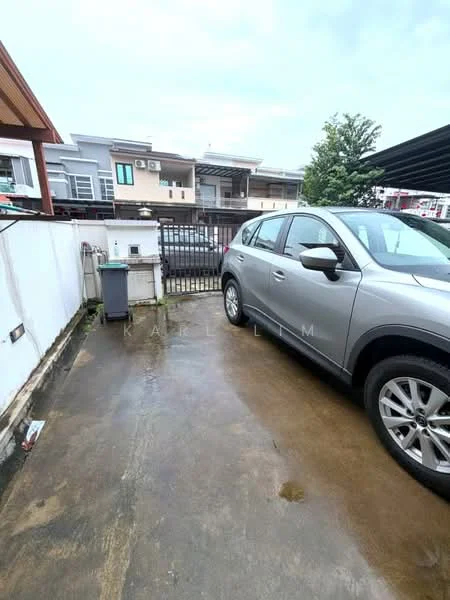 Exterior type: linked terrace house; features: concrete driveway, metal gate, fenced perimeter, car parked, outdoor drainage, surrounding residential buildings, manicured landscaping, partially cloudy sky; style: modern.