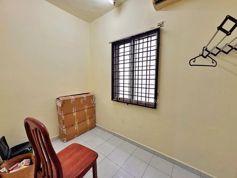 Room features: light yellow painted walls, white tiled flooring, single window with grid pattern, wooden chair, cardboard boxes, clothes rack, air conditioning unit.