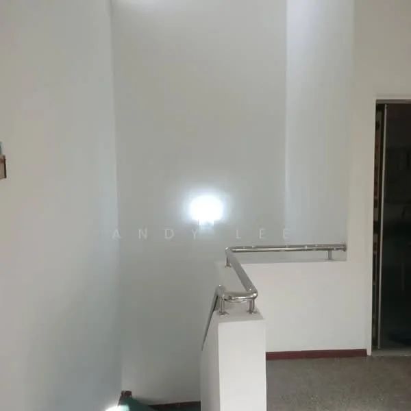Room features: white painted walls, staircase with metal railing, light source illuminating wall, textured flooring, corner wall.