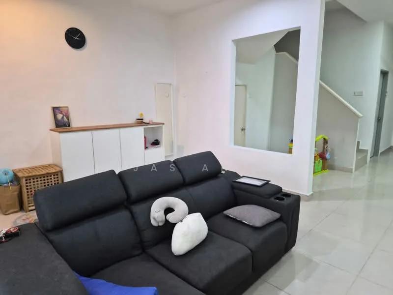 Living features: grey fabric sofa, black throw pillow, white wall clock, white painted walls, tile flooring, open shelving unit, staircase in background, decorative items on shelf, framed artwork, children's toys visible; style: modern.