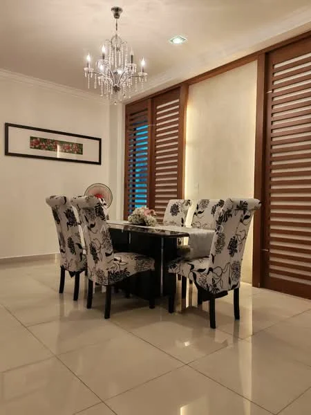 Dining features: 6-seater dining table, black dining table, upholstered dining chairs with floral pattern, chandelier with multiple bulbs, white painted walls, cream tiled flooring, wooden slatted window treatments, decorative wall art; style: modern.