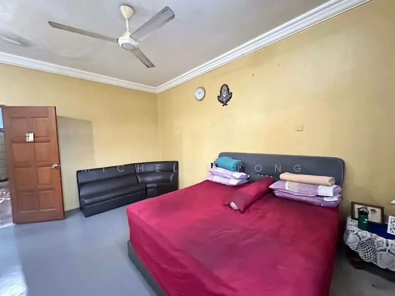 Bedroom features: king-size bed with red bedding, upholstered headboard, sofa in black leather, wooden door, ceiling fan, wall clock, decorative wall mirror, cream painted walls, grey flooring, crown moulding.