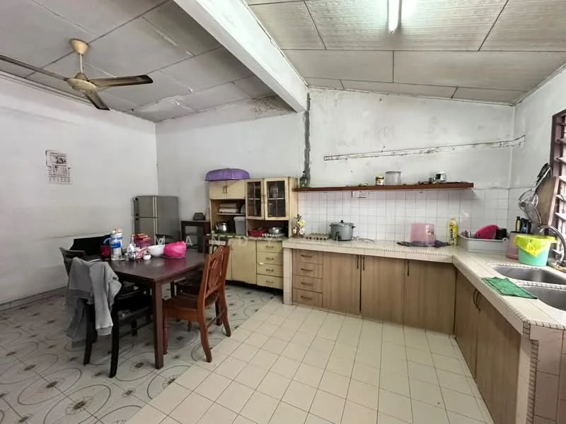 Kitchen features: white tiled walls, grey ceiling, ceiling fan, laminate cabinetry in light brown, countertop with beige tiles, stainless-steel sink, built-in stove, refrigerator, dining table with wooden chairs, floor tiles in cream, open shelving, kitchen utensils on countertop, window with metal grilles; style: functional.