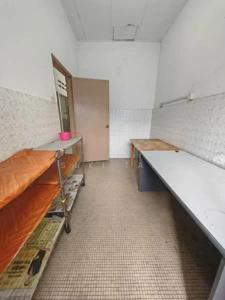 Room features: white tiled walls, grey tiled flooring, wooden countertop, metal shelving unit, orange plastic cover on shelving, single wooden door, fluorescent lighting, empty space, no visible appliances.
