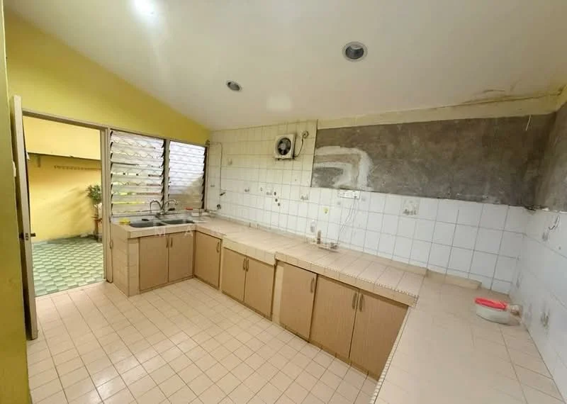 Kitchen features: L-shaped countertop, tile flooring in beige, white tiled backsplash, wood cabinetry in light brown, single-bowl stainless-steel sink, chrome faucet, exposed concrete wall, sliding windows, natural light from window, open layout to outdoor space; view: garden.