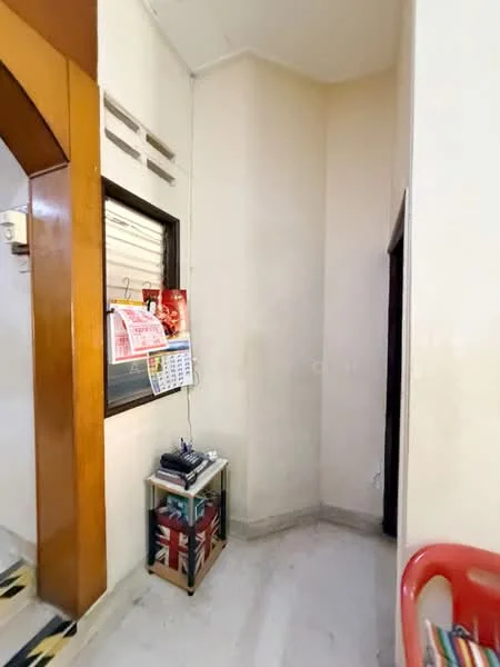Room features: cream painted walls, marble flooring, wooden door frame, window with blinds, calendar on wall, small side table, decorative items on table, corner space; style: modern.