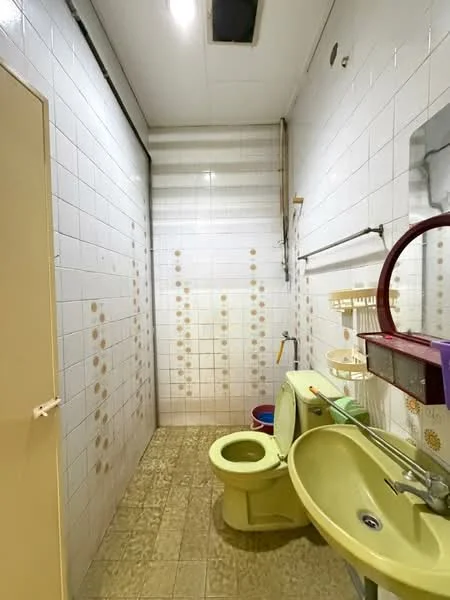 Bathroom features: white tiled walls, yellow toilet, yellow sink, chrome faucet, shower area with no enclosure, tile flooring, wall-mounted mirror, towel rack, plastic storage containers, light fixture on ceiling.