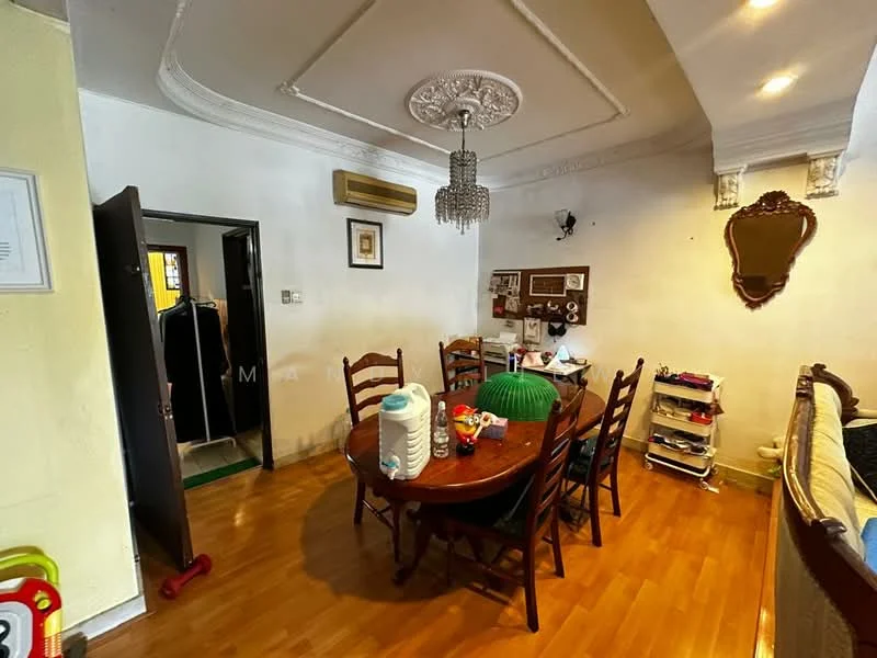 Dining features: wooden flooring, white painted walls, tray ceiling with decorative moulding, chandelier, round wooden dining table, 4 wooden dining chairs, green upholstered chair, decorative mirror on wall, wall-mounted decor board, air conditioning unit, open doorway leading to another room, small shelving unit, houseplants, decorative items on table; style: traditional.