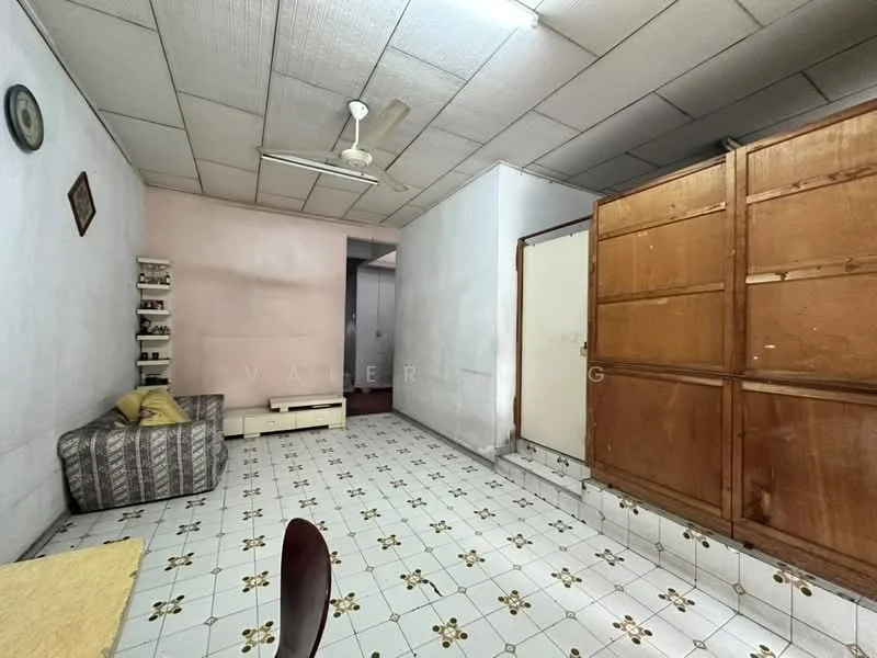 Living features: grey and white striped fabric sofa, wooden coffee table, ceiling fan, white tiled flooring with floral pattern, light pink painted wall, white painted walls, wooden cabinet, shelves on wall, door leading to another room.