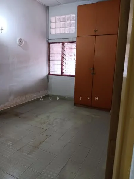 Room features: plain white walls, grey tiled flooring, single window with metal grille, built-in wardrobe with orange finish, no visible ceiling features, no visible lighting fixtures, no visible furniture or decor.