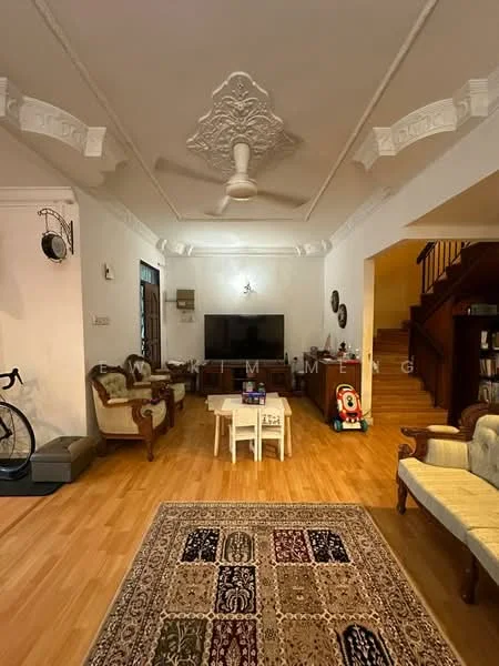 Living features: wooden flooring, white painted walls, tray ceiling with decorative moulding, 5-blade ceiling fan, wall-mounted TV, sofa set with upholstered seats, coffee table, area rug with intricate pattern, decorative wall clock, bicycle, wooden staircase, children's toy, built-in shelving unit; style: traditional.