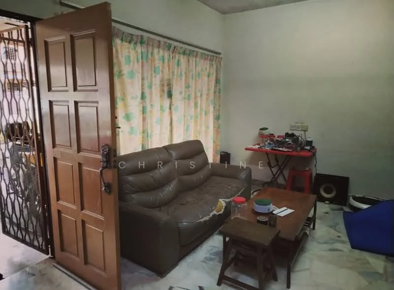 Living features: brown leather sofa, wooden coffee table, marble flooring, floral patterned curtains, wall-mounted electrical outlets, open doorway, decorative items on table, red plastic stools.