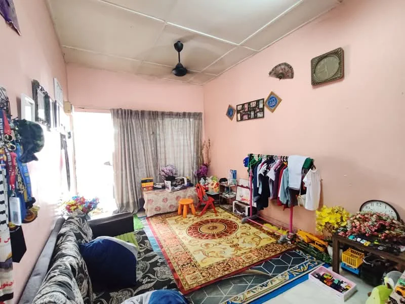 Living features: pink painted walls, ceiling fan, floor-to-ceiling window with sheer curtains, area rug with floral pattern, sofa with patterned upholstery, decorative wall clock, wall-mounted photo frames, clothes rack with assorted clothing, small table with children's chairs, artificial flowers in ceramic pots, tile flooring; style: traditional.