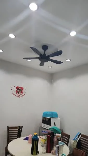 Room features: white painted walls, recessed LED downlights, 5-blade ceiling fan, round dining table, wooden dining chairs, microwave, various bottles and containers on table.