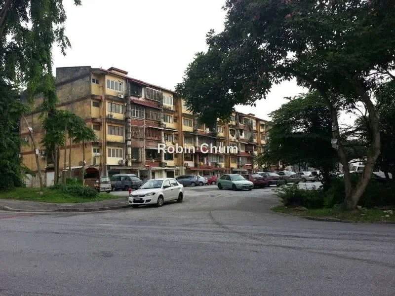 Exterior type: low-rise apartment block; features: multi-storey building, balconies on upper floors, painted facade in yellow and brown, parking lot in front, surrounded by trees, street view, cars parked in lot; style: traditional.