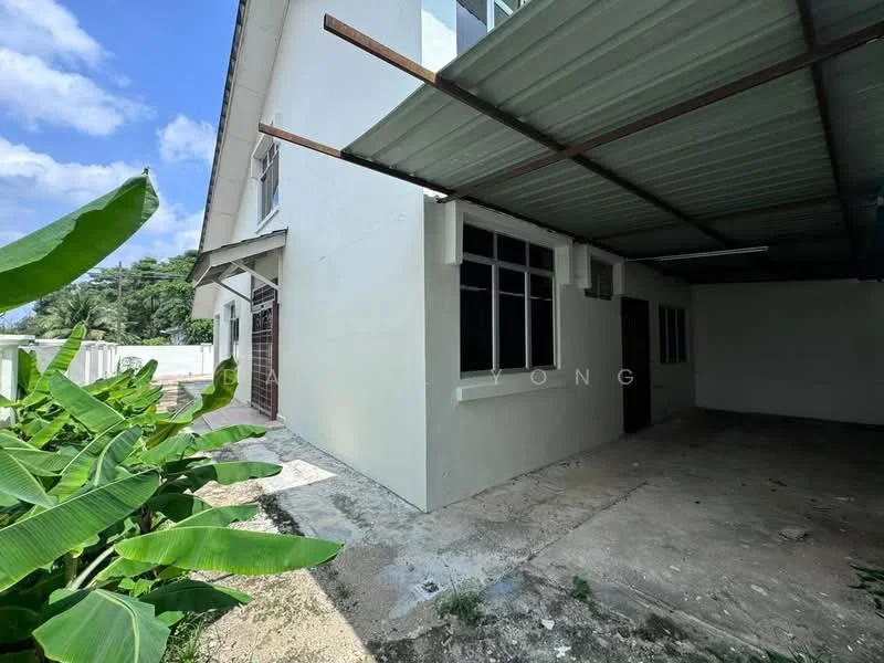 Exterior type: detached bungalow; features: white painted facade, flat roof, carport with metal roofing, concrete flooring, large windows, surrounded by greenery, banana plants in foreground; style: modern.