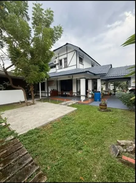 Exterior type: detached bungalow; features: two-storey building, blue tiled roof, white painted facade, wooden balcony, manicured lawn, paved walkway, mature trees, outdoor seating area, garden area, air conditioning unit visible; style: modern.