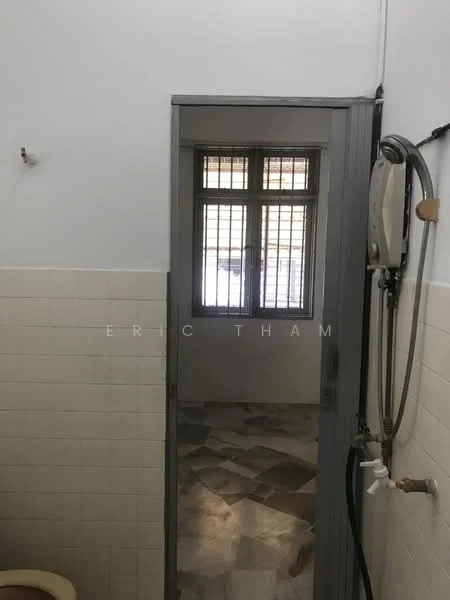 Bathroom features: white tiled walls, grey tiled flooring, shower with wall-mounted water heater, toilet, window with metal grilles.