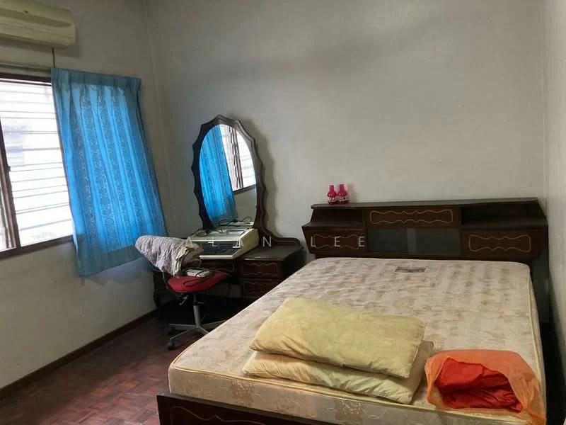 Bedroom features: wooden flooring, white painted walls, blue sheer curtains, double bed with mattress, two pillows, orange cushion, wooden dresser with mirror, desk with chair, window with horizontal slats, air conditioning unit on wall.