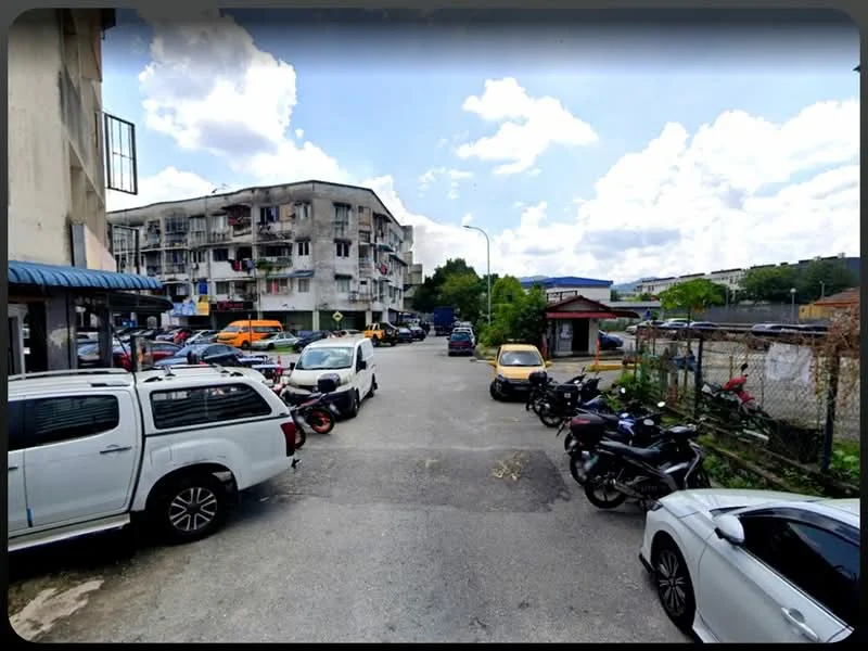 Exterior type: low-rise apartment block; features: multiple parked vehicles, surrounding greenery, street view, two-storey building, balconies visible, road access, fenced area, mixed-use environment; style: traditional.