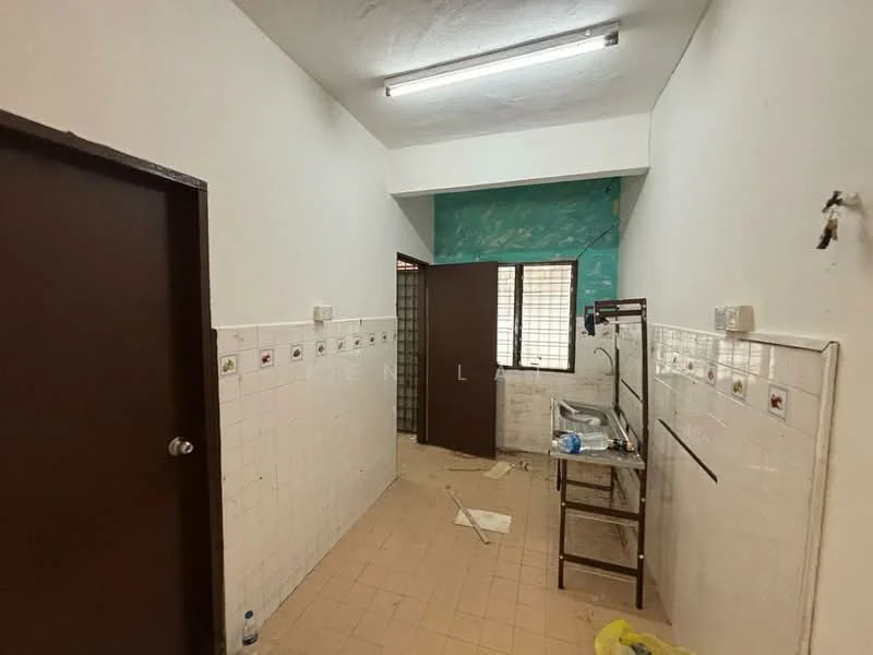 Room features: white tiled walls, light brown tiled flooring, fluorescent ceiling lights, blue painted wall, metal shelving unit, window with metal grille, door with brown finish, cleaning supplies on the floor.